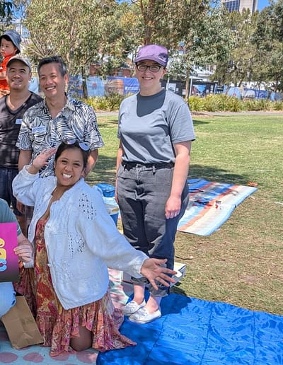Group of people at a picnic holding a sign